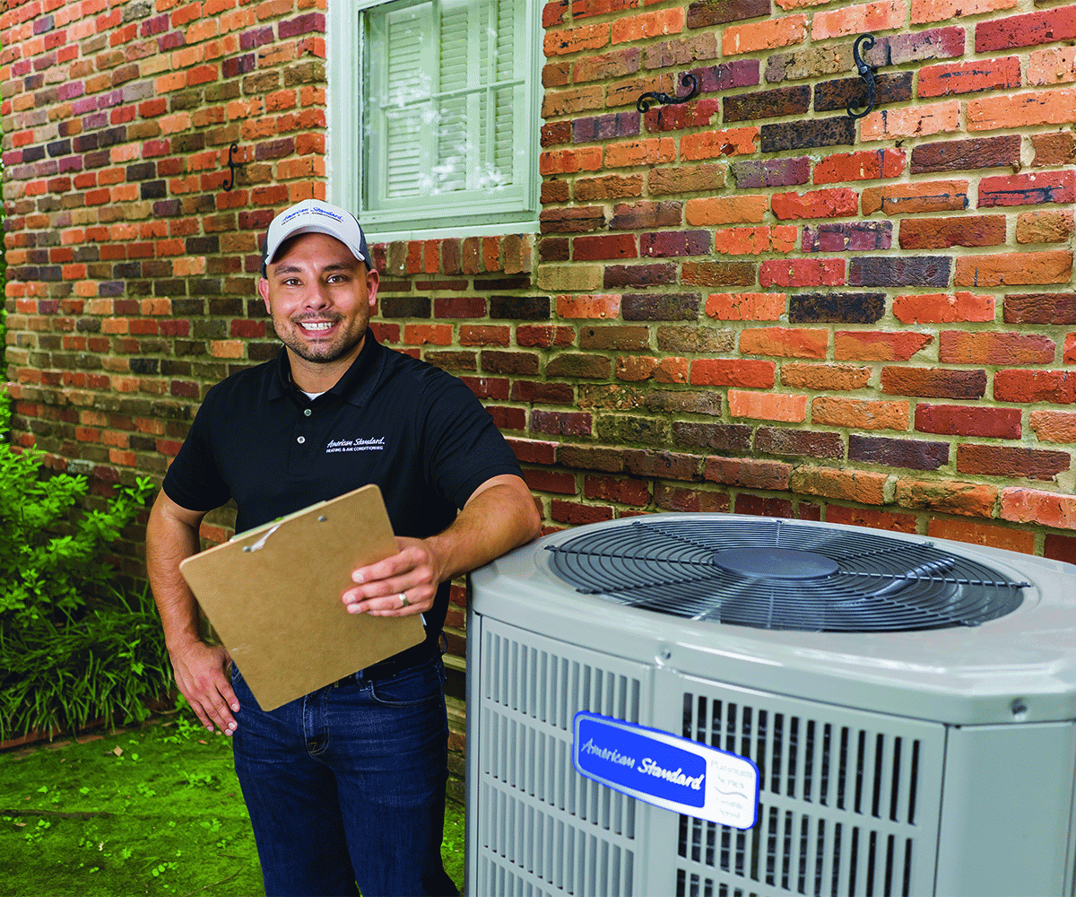 Technician with a clipboard standing beside an outdoor air conditioning unit