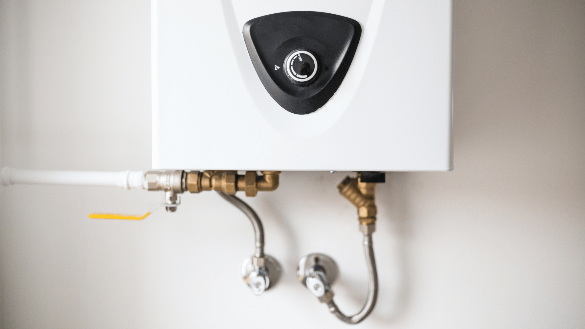 Close-up of a water heater control valve and connected piping