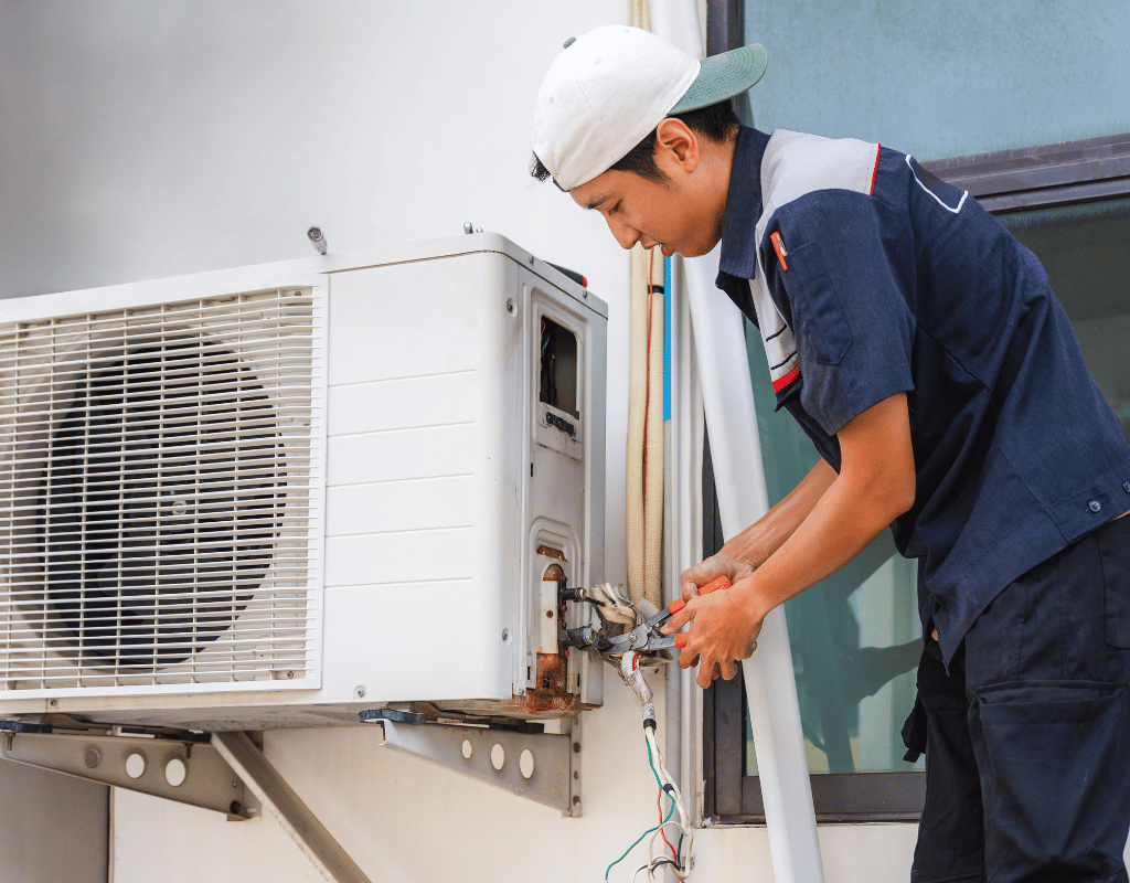 HVAC technician wiring an outdoor ductless minisplit condenser unit